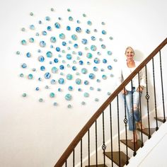 a woman sitting on top of a stair case next to a wall with blue bubbles