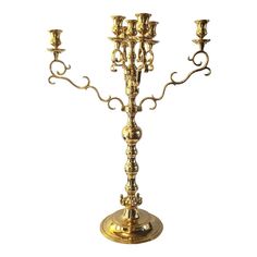 a golden candelabra with three candles on it's sides and four arms