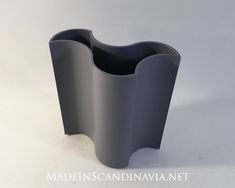 a gray vase sitting on top of a white table