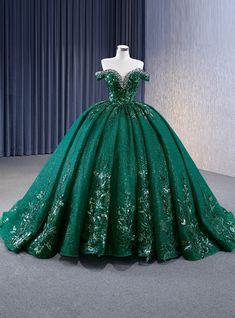 Daringly enchanting, this prom dress is designed to captivate and mesmerize. The rich emerald green hue, adorned with glittering accents, evokes the enchanting beauty of a lush, magical forest. The off-the-shoulder bodice is intricately embellished with sparkling details, highlighting your neckline and shoulders with a touch of elegance and sophistication. The voluminous skirt flows gracefully to the floor, creating a dramatic and regal silhouette. As you move, the shimmering fabric catches the light, creating a magical effect that will captivate everyone around you. Imagine making your grand entrance in this gown, the layers of the skirt swaying with each step, exuding grace and confidence. This dress is perfect for those who want to combine timeless elegance with a hint of modern glamour 15 Dresses Quinceanera Emerald Green, Dark Forest Green Quinceanera Dress, Emerald Sweet 16 Dresses, Forest Green Ball Gown, Dark Green Wedding Dress, Emerald Quinceanera Dress, Emerald Green Quince Dress, Emerald Green Quinceanera Dresses, Green Quince Dress