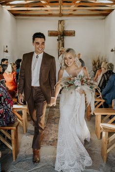 a bride and groom walking down the aisle