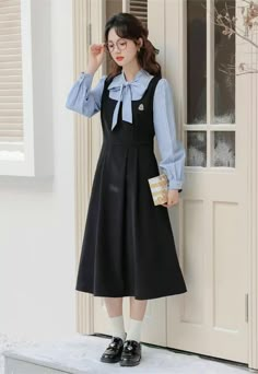 Faux two-piece layered dress with a stripe blouse with two buttons and a tie-up neckline, and a solid colored pinafore dress with a varsity embroidered badge, elastic waist and waist ties. S: 35.5" chest, 27" waist, 42" lengthM: 37" chest, 28.5" waist, 42" lengthL: 38.5" chest, 30" waist, 42" length Flannel Pinafore Dress, Casual Fake Two-piece Dress For Spring, Preppy Dresses For Work In Fall, Preppy Dresses For Fall Workwear, Casual Spring Suspender Dress For Work, Preppy Fall Workwear Dresses, Casual Fake Two-piece Winter Dress, Casual Fake Two-piece Dresses For Winter, Long Sleeve Suspender Dress For Spring