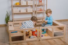 two children playing with wooden toys in a playroom