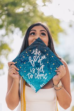 a woman holding up a graduation cap with the words best to get to college written on it