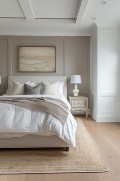 a large white bed sitting in a bedroom on top of a hard wood floored floor