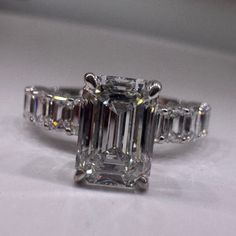 an emerald cut diamond ring with three baguetts