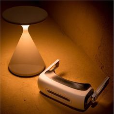 a light that is on top of a table next to a cell phone and a lamp