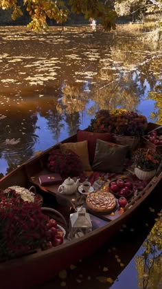 a boat filled with lots of flowers next to a lake covered in water lilies