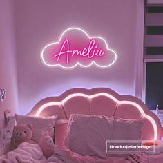 a bed with pink sheets and pillows in front of a neon sign that says amella