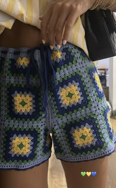 a close up of a person wearing shorts with crocheted designs on the side