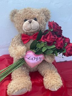 a teddy bear holding roses with the word love written on it