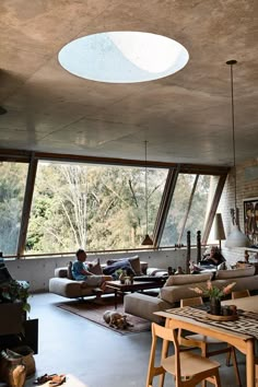 a living room filled with lots of furniture next to a large window covered in sunlight