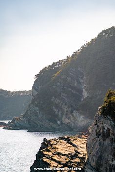 a boat is on the water near some cliffs