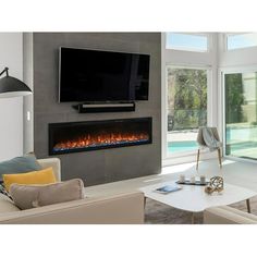 a living room filled with furniture and a flat screen tv mounted on the wall above an electric fireplace