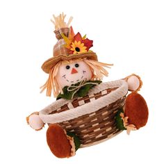 a small scarecrow doll in a basket with leaves on it's head and eyes