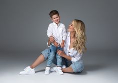 a woman sitting on the ground holding a boy