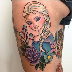 a woman's thigh with an image of a frozen princess tattoo on her leg