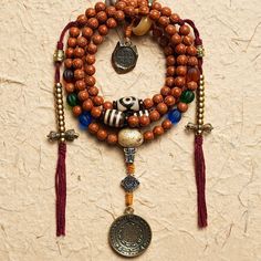 Experience the wisdom of Yama principles and tap into the transformative energy of 108 Bodhi Seed and Tibetan Agate Mala Beads. Explore ancient teachings and wear the lovely Tibetan Agate beads to find inner peace and harmony on your spiritual path. · Material: Bodhi Seed· Yama Pendant: White Copper· Tibetan Astrology Pendant: Brass· Thread: Cotton· Size: 8mm· Process: Handmade (Up to three days) Five- Eyed Bodhi Seed Tibetan Agate Yak Horn Lamp work glass additions The Bell and Dorje Amulets ar Healing Wooden Beads Jewelry For Festivals, Spiritual Wooden Beads Jewelry For Blessing, Spiritual Jewelry With Wooden Beads For Blessing, Spiritual Wooden Beads Jewelry For Meditation, Traditional Mala With Natural Stones For Meditation, Spiritual Brown Agate Beads, Spiritual Wooden Beads Mala For Festival, Handmade Amulet Mala For Meditation, Holistic Mala With 108 Beads For Festival