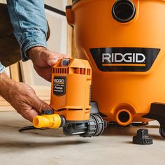 a man is using a vacuum to clean the floor