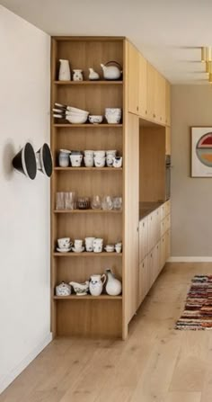 a kitchen with wooden cabinets and white dishes