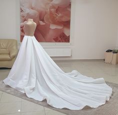 a white wedding dress on display in a room