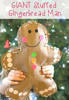 a child holding up a gingerbread man made out of paper