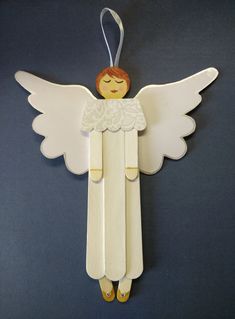 a wooden angel ornament hanging on a wall