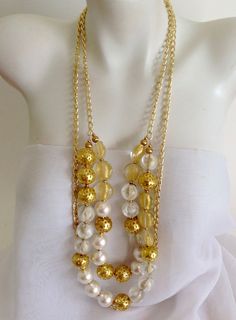 "White 20mm pearls, gold plated pewter beads, clear acrylic beads with gold foil and gold lamp worked Czech glass beads are combined with gold plated curb chain in this festive, elegant long multi strand design. Necklace is 35\" long and adjusts to 39\" with chain extender, closes with a large gold plated lobster clasp and has been strung on flexible nylon coated stainless steel stringing wire for strength and durability.     My sterling silver hand stamped maker's mark tag hangs from end of necklace.  Handmade in the USA by Lia Galletti at the LIA Jewelry Designs studio in Fort Myers, FL A distinctive statement of taste any time of day or night which will make you proud to wear or give. Each piece of handmade beaded jewelry is unique and one-of-a-kind. All my jewelry will arrive wrapped i Jewelry Design Studio, Coral Jewelry, Handmade Beaded Jewelry, Chain Extenders, Necklace White, Handcrafted Necklace, Necklace Statement, Chain Gold, Chunky Necklace