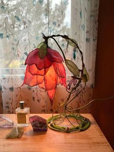 a lamp sitting on top of a wooden table next to a vase and other items