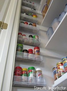 an open refrigerator door with canned food in containers on the bottom shelf and shelves below