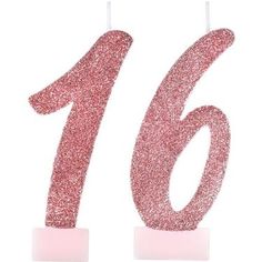 the number sixteen candle has pink glitter on it's base and stands in front of a white background