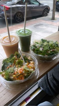 salad and drinks are sitting on a window sill