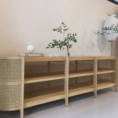 a wooden shelf with two vases on top of it next to a wall mounted planter