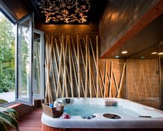 a large jacuzzi tub sitting on top of a wooden floor next to a window