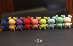 there are many small stuffed animals lined up in a row on the table next to each other