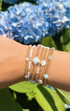 Embrace the beachy vibes with our Cove Beaded Bracelet! This stretch bracelet features delicate galvanized gold seed beads paired with round, natural shell beads in a subtle, ocean-inspired pattern. Lightweight and easy to wear, it’s perfect for layering or wearing solo to add a touch of coastal charm to your look. A must-have accessory for surf lovers and seaside adventurers! Please refer to the bracelet size chart for your bracelet size. Elegant Heishi Bead Bracelets With Tiny Beads, Elegant Gold Beaded Bracelets For Summer, Elegant Stackable Beaded Bracelets For Beach, Elegant Tiny Beads Bracelet For Beach, Adjustable Gold Pearl Bracelet For Summer, Dainty Adjustable Beaded Bracelet With Round Beads, Elegant Colorful Beaded Bracelets For Summer, Dainty White Bracelet With Gold Beads, Elegant Tiny Beads Friendship Bracelets For Beach