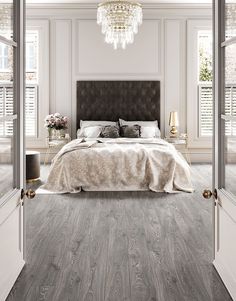 a large bed sitting inside of a bedroom on top of a hard wood floored floor