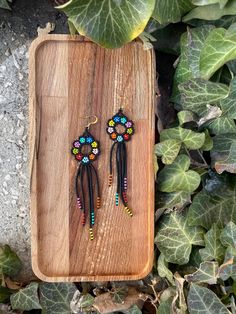 Beaded Boho Earrings, Huichol Earrings, Boho Colorful Flower Earrings, Indigenous Made, Traditional Beadwork, Seed Bead Fringe Earrings ♥𝑇ℎ𝑒 𝑝𝑎𝑡𝑡𝑒𝑟𝑛 𝑜𝑓 𝑡ℎ𝑖𝑠 𝑒𝑎𝑟𝑟𝑖𝑛𝑔 𝑖𝑠 𝑐𝑟𝑒𝑎𝑡𝑒𝑑 𝑏𝑦 𝐾𝑎𝑍𝑒𝐵𝑒𝑎𝑑𝐽𝑒𝑤𝑒𝑙𝑟𝑦 ♥𝑀𝑎𝑑𝑒 𝑢𝑠𝑖𝑛𝑔 𝑓𝑟𝑒𝑒ℎ𝑎𝑛𝑑 𝑏𝑒𝑎𝑑𝑖𝑛𝑔 𝑤𝑜𝑣𝑒𝑛 𝑡𝑒𝑐ℎ𝑛𝑖𝑞𝑢𝑒𝑠 𝑤𝑖𝑡ℎ 𝑠𝑡𝑟𝑜𝑛𝑔 𝑠𝑦𝑛𝑡ℎ𝑒𝑡𝑖𝑐 𝑡ℎ𝑟𝑒𝑎𝑑. ♥𝑇ℎ𝑒 𝑠𝑖𝑧𝑒 𝑜𝑓 𝑡ℎ𝑒 𝑠𝑒𝑒𝑑 𝑏𝑒𝑎𝑑𝑠 𝑢𝑠𝑒𝑑 𝑖𝑠 2 𝑚𝑖𝑙𝑙𝑖𝑚𝑒𝑡𝑒𝑟𝑠 𝑎𝑛𝑑 𝑏𝑒𝑎𝑑𝑠 𝑎𝑟𝑒 ℎ𝑖𝑔ℎ 𝑞𝑢𝑎𝑙𝑖𝑓𝑖𝑒𝑑. ♥𝐴𝑙𝑙 𝑡ℎ𝑒 ℎ𝑜𝑜𝑘𝑠 𝑢𝑠𝑒𝑑 𝑖𝑛 𝑜𝑢𝑟 𝑗𝑒𝑤𝑒𝑙𝑟𝑦 𝑎𝑟𝑒 24 𝑘 𝑔𝑜𝑙𝑑 𝑝𝑙𝑎𝑡𝑒𝑑 𝑎𝑛𝑑 ℎ𝑦𝑝𝑜𝑎𝑙𝑙𝑒𝑟𝑔𝑒𝑛𝑖𝑐. ♥𝑇ℎ𝑒𝑠𝑒 𝑎𝑟𝑒 𝑣𝑒𝑟𝑦 𝑙𝑖𝑔ℎ𝑡 𝑒𝑎𝑟𝑟𝑖𝑛𝑔𝑠 𝑡ℎ𝑎𝑡 𝑦𝑜𝑢 𝑐𝑎𝑛 𝑤𝑒𝑎𝑟 𝑎𝑙𝑙 𝑑𝑎𝑦 𝑤𝑖𝑡ℎ𝑜𝑢𝑡 ℎ𝑢𝑟𝑡𝑖𝑛𝑔 𝑦𝑜𝑢𝑟 𝑒𝑎𝑟! The only a Multicolor Beaded Flower Earrings, Multicolor Bohemian Dangle Flower Earrings, Beaded Flower Dangle Earrings For Beach, Adjustable Multicolor Flower Earrings With Colorful Beads, Beach Dangle Earrings With Black Beads, Festival Flower Dangle Earrings With Beads, Black Flower-shaped Jewelry With Colorful Beads, Adjustable Flower-shaped Earrings With Dangling Beads, Multicolor Drop Flower Earrings For Festival