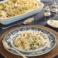 a plate with noodles and vegetables on it next to a casserole dish