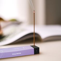 an electronic device that is sitting on a table with a book in front of it