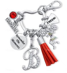 a red tasseled keychain with charms on it and the words graduate