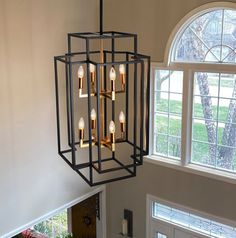 a chandelier hanging from the ceiling in a room with two windows and a door