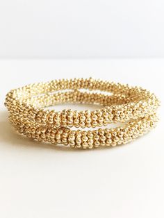 Medium Gold Stacking Bracelets ⟡ all items are designed and handcrafted in our studio ⟡14kt gold plated beads on stretch material. These stunning minimalist gold bracelets epitomize the essence of metallic sophistication. Their flexible design makes layering with other bracelets or a wristwatch a breeze. Elevate your fashion and indulge in a delightful new accessory that infuses a hint of opulence into any outfit.This listing is for one bracelet.OVERVIEW-7.25 inches long-14kt gold plated beadsLo Gold Wrap Bracelet With Tiny Beads As A Gift, Gold Hand-strung Wrap Bracelet Gift, Handmade Gold Bracelet In 14k Gold Filled, Gold Beaded Bracelet With Tiny 14k Gold Filled Beads, Gold 14k Gold-filled Tiny Beaded Bracelets, Elegant Gold Stretch Bracelet Stackable, Handmade Gold-plated Beaded Bracelets, Gold Beaded Stretch Bracelet For Party, Adjustable Gold Stretch Bracelet Stackable