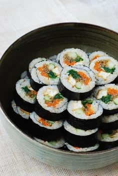 a bowl filled with lots of sushi on top of a table