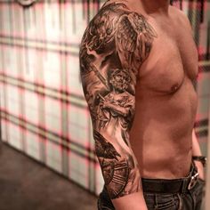 a man with tattoos on his arm and chest standing in front of a tiled wall