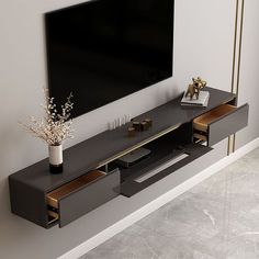 an entertainment center with a large flat screen tv mounted on the wall and gold trimmings