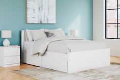 a bedroom with blue walls and white furniture