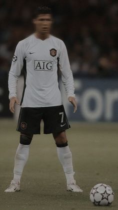 a man standing next to a soccer ball on a field