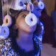 a woman with doughnuts hanging from her head in front of her eyes and nose