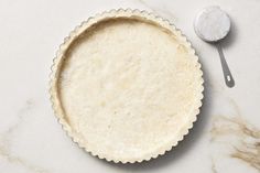 an uncooked pie crust next to a spoon